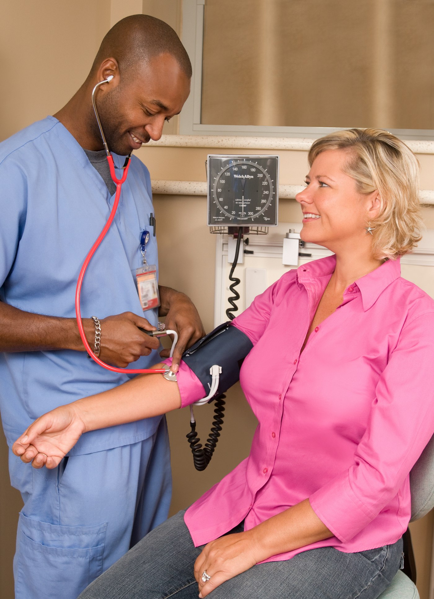 Home health nurse checking a patient's blood pressure during a home visit