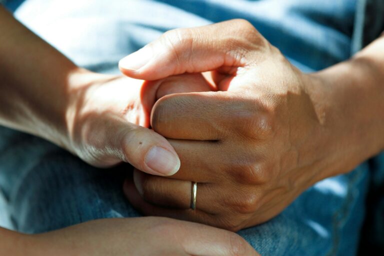 Caregiver holding the hand of a stroke patient recovering at home